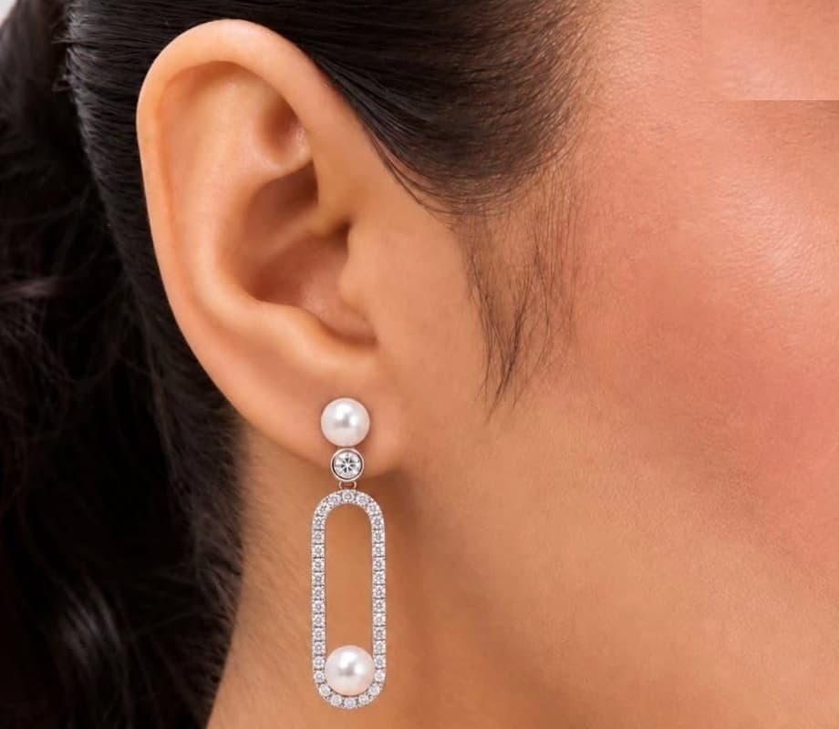 Perle pearl and diamond drop earring worn on the ear, elongated diamond pavé oval with pearl accents
